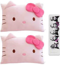 two pink hello kitty pillows and a remote control