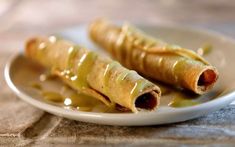 some food is on a white plate and drizzled with sauce, ready to be eaten