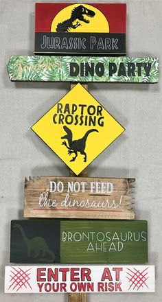 there are many signs on the wall that say dinosaurs, raptor crossing, do not feed the dinosaurs, enter at your own risk