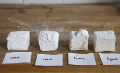 four different types of marshmallows sitting on top of a wooden table