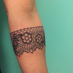 a woman's arm with a black lace design on the top and bottom of it