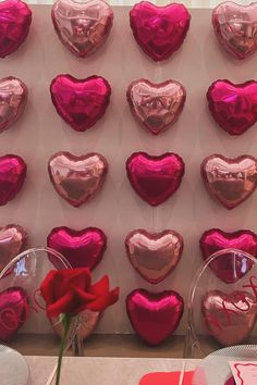 valentine's day decorations are displayed on the wall in front of a red rose