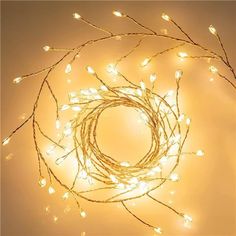 a lighted wreath with white lights in the shape of a circle on top of a wall