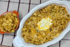 a casserole dish with cornflakes and an egg in it on a table