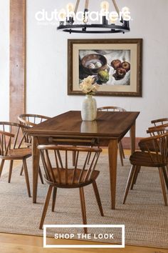 a dining room table and chairs in front of a painting with the words shop the look