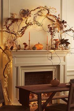 the fireplace is decorated with pumpkins and greenery