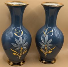 two blue vases with flowers painted on them