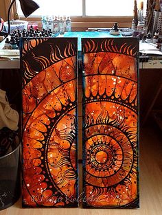 an orange and black art piece sitting on top of a wooden table next to a window