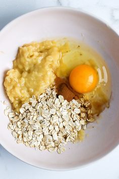 an egg, oatmeal and other ingredients in a white bowl