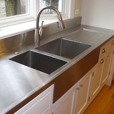 stainless steel kitchen sink with two pears on the window sill