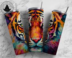 three colorful tiger tumblers sitting next to each other on a white marble counter top