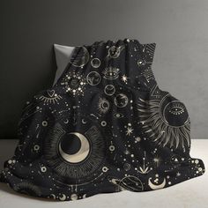 an artistic black and white blanket with sun, moon and stars on it