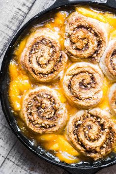 cinnamon rolls in a cast iron skillet on a wooden table, ready to be eaten