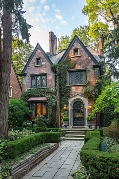 a large brick house with lots of greenery on it's front door and walkway