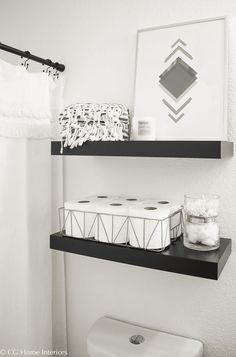 black and white bathroom with two shelves above the toilet