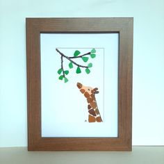 a giraffe standing next to a tree branch with leaves on it's head