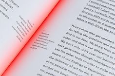 an open book with red light coming out of the pages and writing on top of it