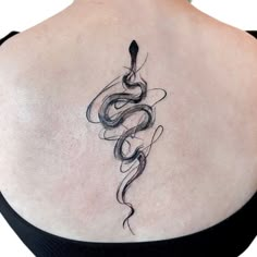 a woman's back with a snake tattoo on it