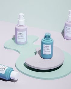 three bottles of skin care sitting on top of a table