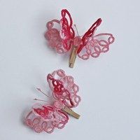 two small pink butterfly clips on a white surface