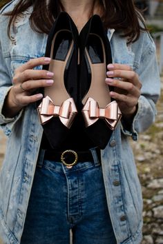 a woman holding two pairs of shoes in her hands