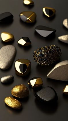 several different types of rocks on a black surface with gold and silver shapes in the middle