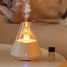 a white humider sitting on top of a table next to a bottle of essential oils