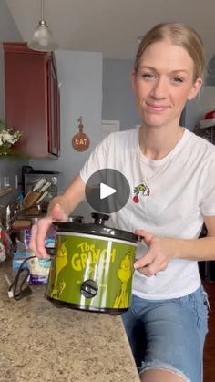 a woman sitting at a kitchen counter with a green crock pot