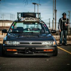 a black car parked in front of a man standing next to it