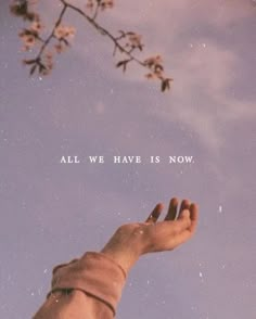 a hand reaching up into the sky with an all we have is now quote