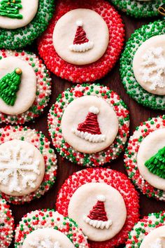 christmas cookies decorated with icing and sprinkles are arranged on a table