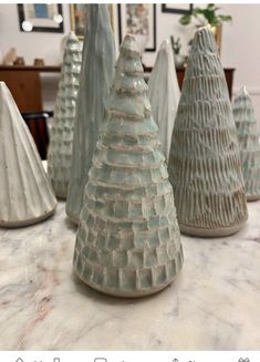 four ceramic trees sitting on top of a table