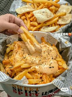 a basket filled with french fries covered in sauce