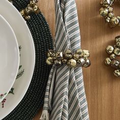 a place setting with napkins and bells on the table next to eachother