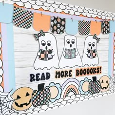 a sign that says read more books with ghostes on it and other decorations hanging from the wall