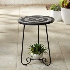 a black and white table with a potted plant on the top in front of it