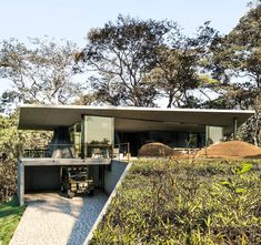 the house is surrounded by trees and grass, with an outdoor dining area on one side