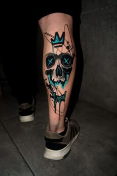 a man's leg with a skull and crown tattoo on it