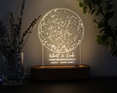 a night light with stars on it sitting next to a vase filled with dried flowers