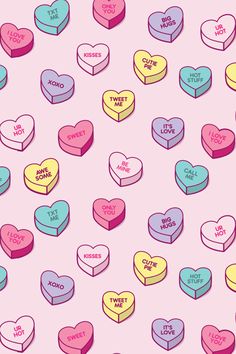 many heart shaped candies are on a pink background with the words i love you