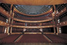 the inside of a large auditorium with rows of seats and an overhead dome above it