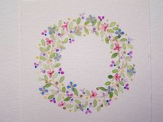 an image of a wreath made out of flowers and leaves on white paper with watercolor pencils