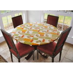 a dining room table with four chairs and a quilted tablecloth on the top