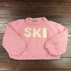 The Ski Pullover In Pink With White Letters, Sporty W/Raglan Sleeves And A Mock Neck. One Size Fits All (Width: 23.5”, L 19.5”, Arm 29”). Hand Knit In Canada Ski Sweater, White Letters, Christmas 2024, Raglan Sleeve, One Size Fits All, Mock Neck, Hand Knitting, Pink Ladies, Skiing