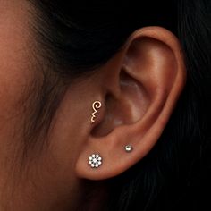 a close up of a person's ear with two different piercings on it