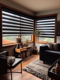 a living room filled with furniture and large windows covered in black blindes on top of them