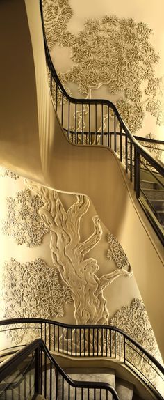 two spiral staircases with artistic wallpaper on the walls