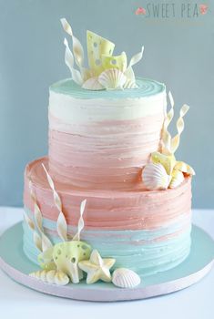 a multi layer cake with sea shells on top