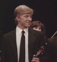 the young man is holding an award for his performance in the musical show, which was presented