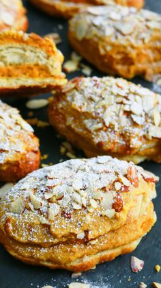 several pastries with almonds and powdered sugar on top